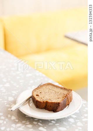 Moist Peanut butter Banana bread sliced with sauce on ceramic plate by the window. 131594333