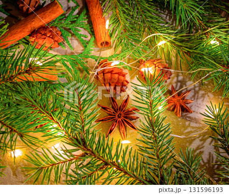 A Christmas photo featuring natural star anise and cinnamon sticks, along with fir branches and pine cones 131596193
