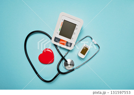 stethoscope, heart model, pills, and digital devices on Pale Blue Background symbolizing love and care in the medical field. stethoscope, heart model, pills, and digital devices on Pale Blue Background symbolizing love and care in the medical field. 131597553