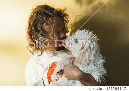 Young Girl Embraced by Puppy Sharing Affectionate Licks 131598147