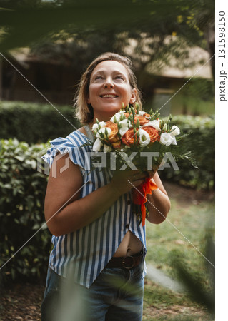 Woman Smiling Joyfully Holding a Fresh Flower Bouquet 131598150