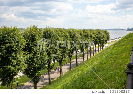 View from the top of the hill slope to the embankment with trees in a row 131598857