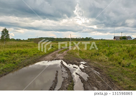 Storm clouds, puddles and mud at a rural road fork - dramatic countryside landscape Storm clouds, puddles and mud at a rural road fork - dramatic countryside landscape 131598865