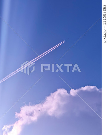 Jet plane with pink contrails in purple sky and clouds, vertical shot Jet plane with pink contrails in purple sky and clouds, vertical shot 131598868