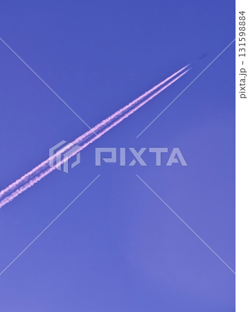 Jet airplane with purple contrails in clear sky, minimalism, vertical 131598884