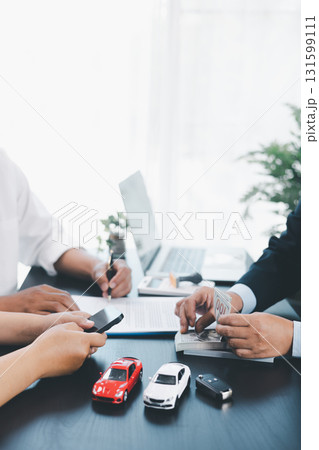 Customer signing car loan contract with dealer showing vehicle model, concept of auto finance, leasing, insurance or purchase agreement, business negotiation and financial planning. auto finance. 131599111