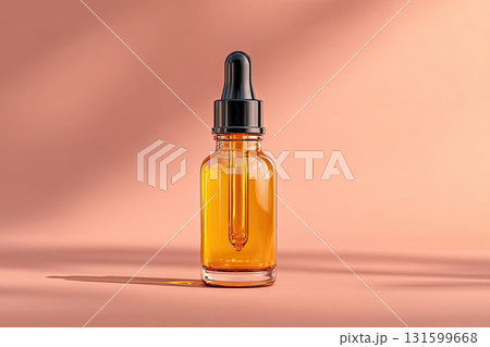Amber glass dropper bottle with liquid on peach background Amber glass dropper bottle with liquid on peach background 131599668