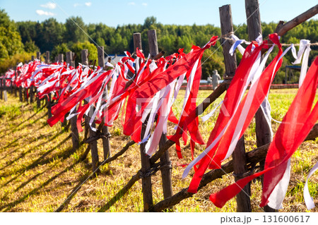 Wooden fence decorated with red and white ribbons at folk festival Wooden fence decorated with red and white ribbons at folk festival 131600617