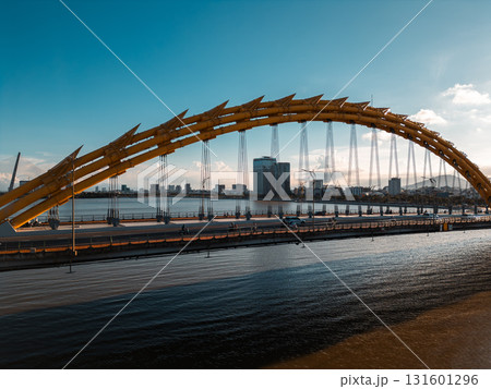Golden Dragon Bridge over Han River in Da Nang at sunset, Iconic Vietnamese landmark spanning urban waterway with city skyline view 131601296