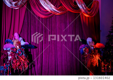 Party decor with masks, and feathers against a backdrop of purple curtains 131601402
