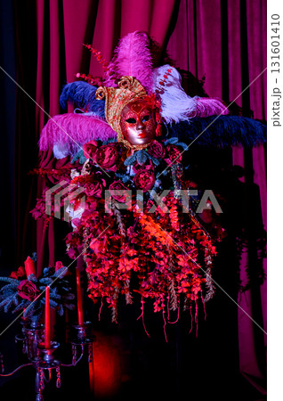 Party decor with masks, and feathers against a backdrop of purple curtains Party decor with masks, and feathers against a backdrop of purple curtains 131601410