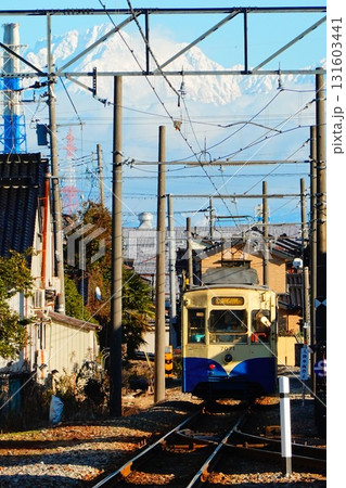 新町口駅に入線する万葉線デ7071形と立山連峰 131603441