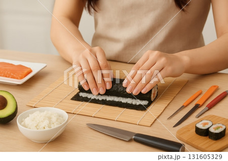Woman rolling fresh salmon avocado sushi maki at home kitchen 131605329