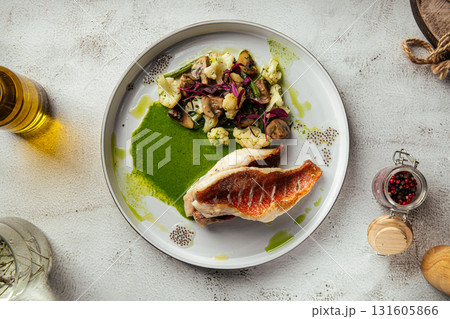 Grilled sea bass with vegetables and green sauce Grilled sea bass with vegetables and green sauce 131605866