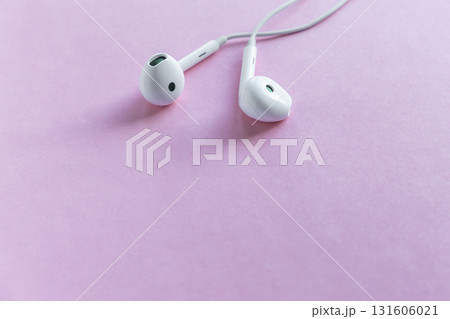 earphones on soft pink background creating vibrant atmosphere in minimalist setting. closeup. earphones on soft pink background creating vibrant atmosphere in minimalist setting. closeup. 131606021