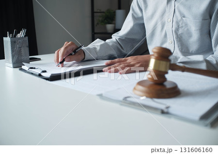 Legal justice man working on desk reading supportive documents to determine the case Legal justice man working on desk reading supportive documents to determine the case 131606160