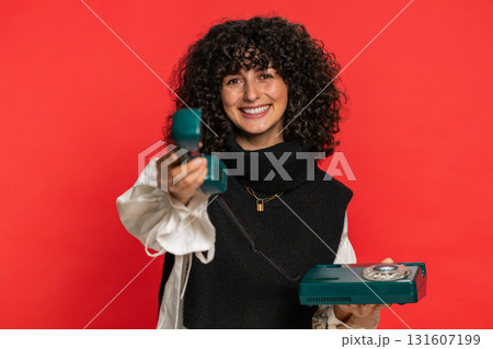 Young woman talking on wired landline vintage telephone, advertising proposition of conversation Young woman talking on wired landline vintage telephone, advertising proposition of conversation 131607199