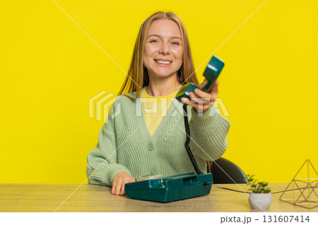 Woman advertising phone call having conversation on wired retro telephone helpline hotline support Woman advertising phone call having conversation on wired retro telephone helpline hotline support 131607414