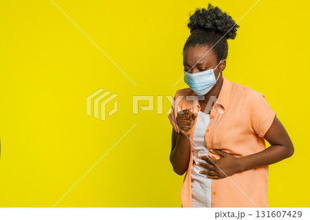 African American woman putting on medical mask tired expression covering nose and mouth health focus 131607429