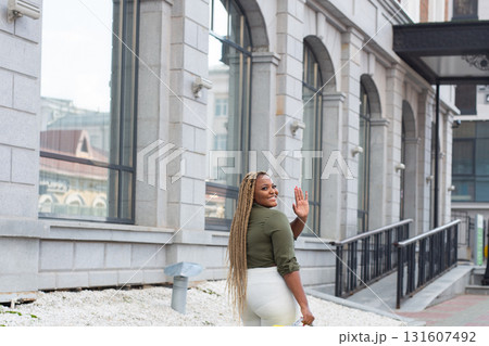 African american smiling woman looking back in the city streets. Joy, confidence, and positive emotions in an urban environment. 131607492
