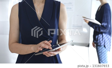 Businesswoman using digital tablet during corporate meeting, collaborating with colleagues in a modern office, planning strategies for project development and success Businesswoman using digital tablet during corporate meeting, collaborating with colleagues in a modern office, planning strategies for project development and success 131607653