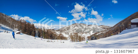快晴のスキー場で大勢の修学旅行生がスキーを楽しむ冬のパノラマ風景 (長野県、斑尾高原) 131607967