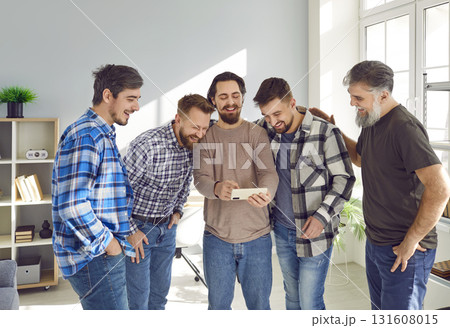 Overjoyed smiling male friends watching funny photos or video on smartphone and having fun together Overjoyed smiling male friends watching funny photos or video on smartphone and having fun together 131608015