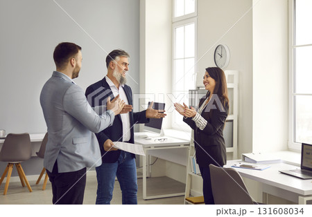 Business people applauding their successful colleague in office Business people applauding their successful colleague in office 131608034