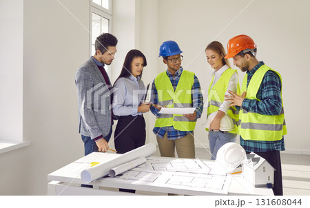 Team of diverse architects and engineers discussing construction plan during office meeting 131608044
