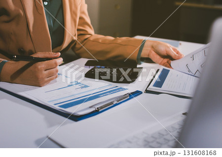 Close-up of businessman's hands making notes, mobiles, chart, desk, office Close-up of businessman's hands making notes, mobiles, chart, desk, office 131608168