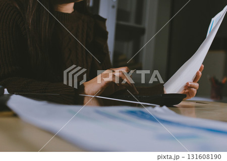 Close-up of businessman's hands making notes, mobiles, chart, desk, office Close-up of businessman's hands making notes, mobiles, chart, desk, office 131608190