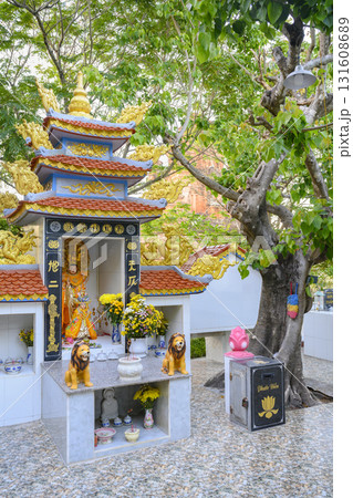 Buddhist gilded altar with sculptures and flowers outdoors under an old tropical tree Buddhist gilded altar with sculptures and flowers outdoors under an old tropical tree 131608689
