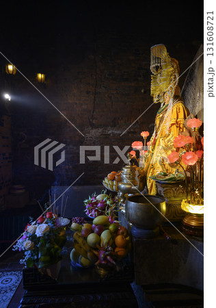 Sacred religious statue with offerings, flowers and candles in the Cham Tower Sacred religious statue with offerings, flowers and candles in the Cham Tower 131608721