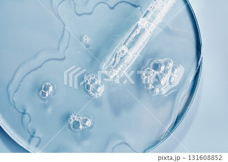 Clear gel serum with bubbles and dropper on petri dish surface Clear gel serum with bubbles and dropper on petri dish surface 131608852