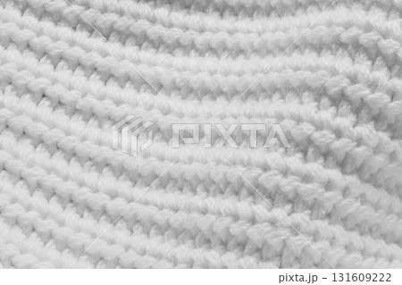A close up of a white knit sweater A close up of a white knit sweater 131609222