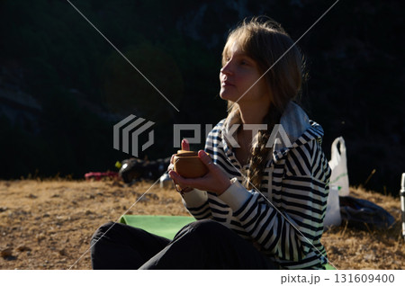 Woman Outdoors Enjoying Tea Cup Moment On A Quiet Dusk Camping Trip 131609400