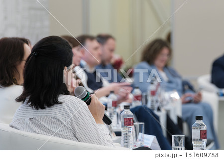 Rear view of woman speaking at a professional group discussion 131609788