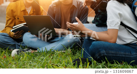 Happy students walking together on university campus, chatting and laughing outdoors after classes 131609867