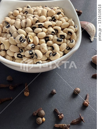 Black-eyed peas in white bowl on a black surface. Healthy, wholesome, plant-based food. 131610018