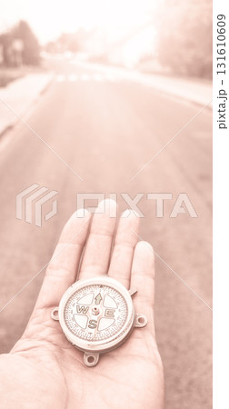 A compass in hand, conceptual photo, selective focus, color toning applied. A compass in hand, conceptual photo, selective focus, color toning applied. 131610609