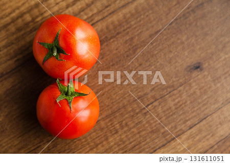 Fresh, tasty organic vegetables, two red tomato, isolated on brown wood cutting board 131611051