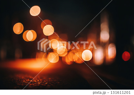 Defocused view of orange bokeh lights on dark background at night 131611201