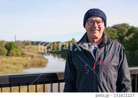 Portrait of a smiling senior man in sportswear on the bridge Portrait of a smiling senior man in sportswear on the bridge 131611227