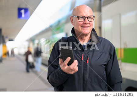 Portrait of senior man using mobile phone at the train station Portrait of senior man using mobile phone at the train station 131611292