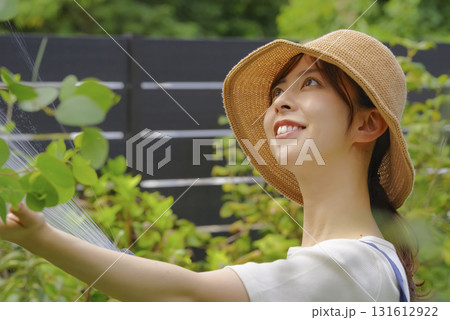 庭の植物に丁寧に水をあげる女性 庭の植物に丁寧に水をあげる女性 131612922