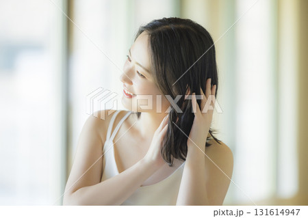 リビングでヘアケアをする女性 リビングでヘアケアをする女性 131614947
