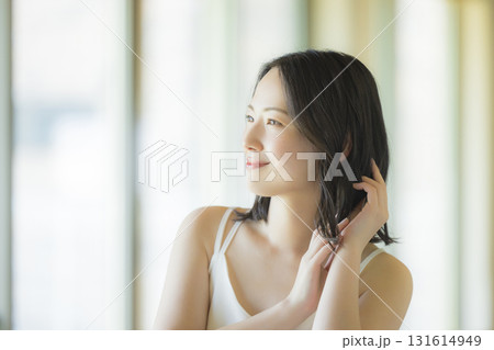 リビングでヘアケアをする女性 リビングでヘアケアをする女性 131614949