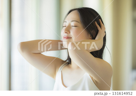 リビングでヘアケアをする女性 131614952