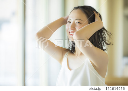 リビングでヘアケアをする女性 131614956
