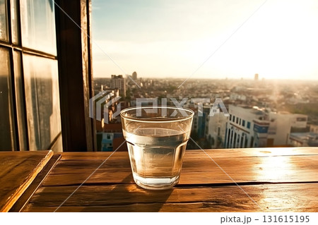 Fresh Water Glass on Wooden Table with Cityscape View at Sunset 131615195